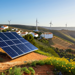 Sustainable Energy Transition in Portugal**

"A modern solar panel installation on a hillside in the Algarve region of Portugal, overlooking a traditional whitewashed village. In the background, wind turbines are subtly visible on the horizon. The scene is bathed in warm, golden sunlight, illustrating a clean energy future. Include vibrant wildflowers in the foreground. Safe for work, appropriate content, fully clothed, professional photography, perfect anatomy, natural proportions, high quality, professional, modest."

**